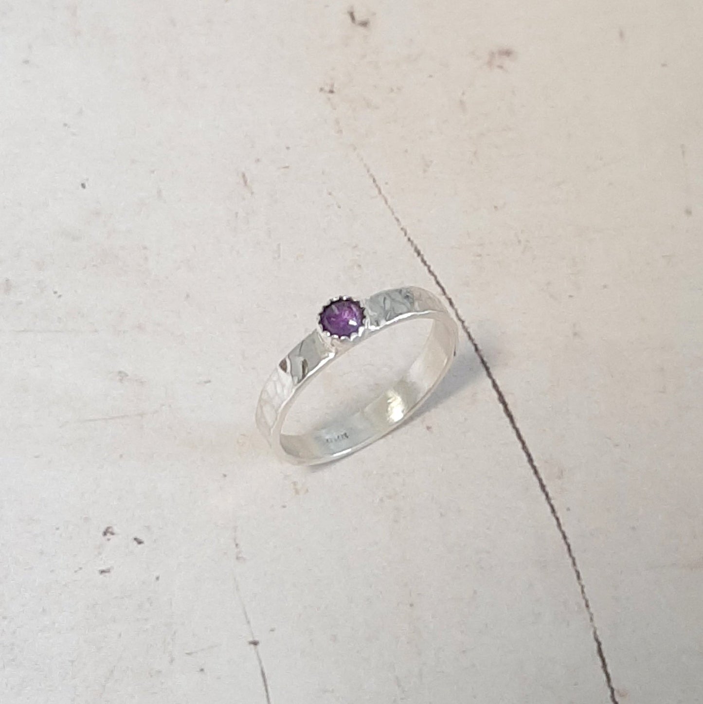 Bague en argent 925 martelé à la main, rehaussée par une améthyste naturelle. Finition brillante. Cette pierre fine, connue pour ses vertus apaisantes, apporte une touche de sérénité et d'élégance à ce bijou unique.