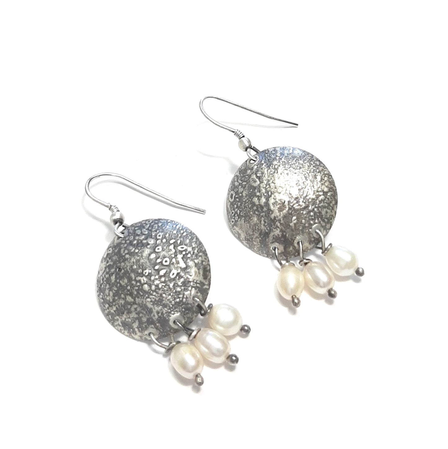 Boucles d’oreilles artisanales en argent massif, patine noire et perles de culture. Un style authentique et féminin.