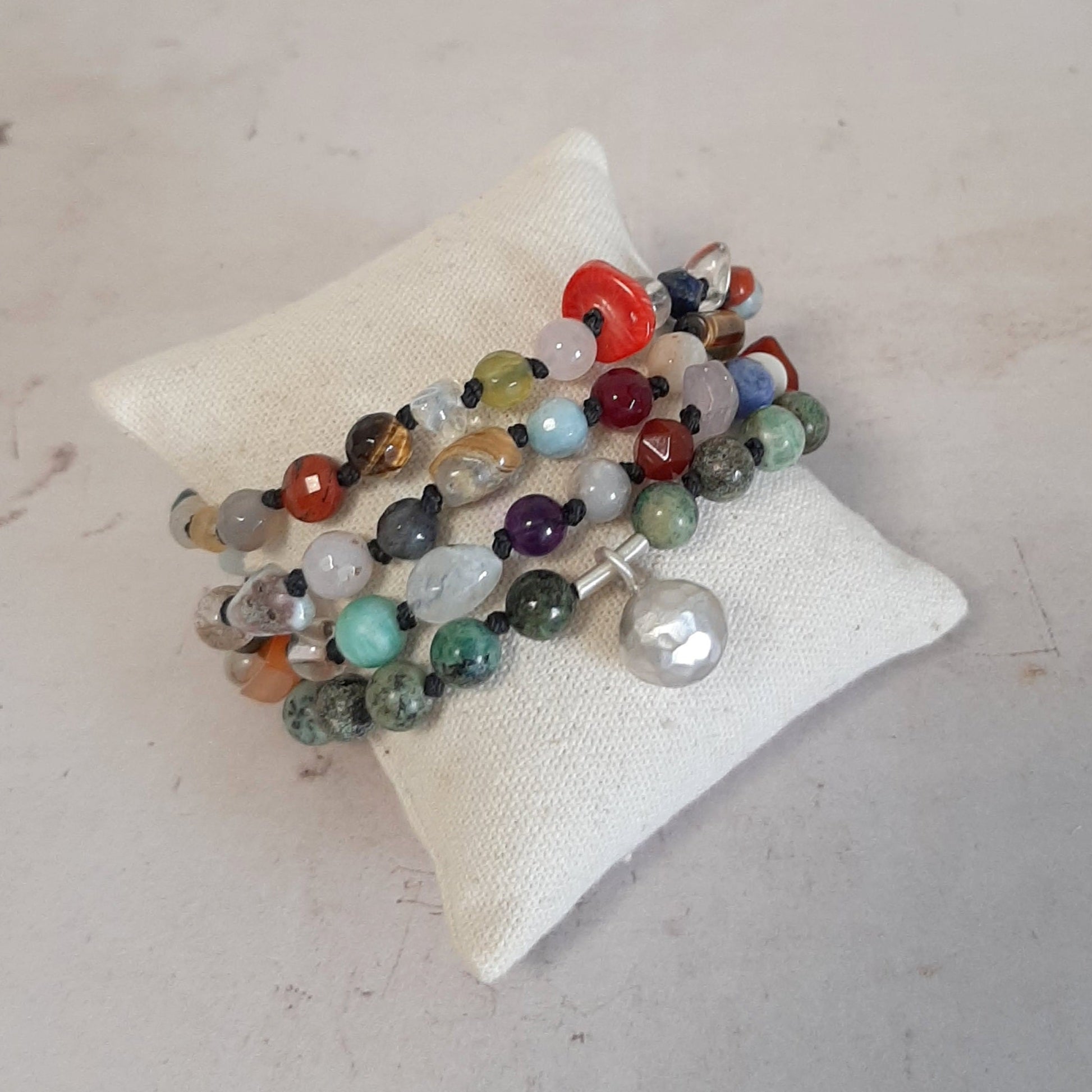 Un bracelet spirituel en pierres naturelles multicolores  grelot appeleur d’anges. Énergie positive et charme artisanal.