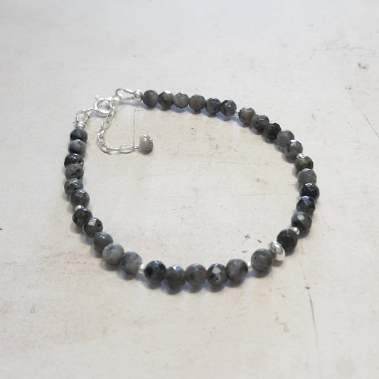 Bracelet discret en argent 925 et labradorite noire, également connue sous le nom de larvikite. Mesurant 17 cm, ajustable grâce à une délicate chainette,