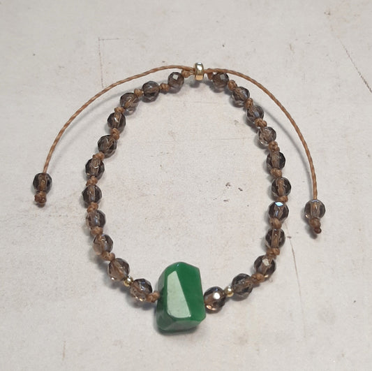 Bracelet en Quartz fumé et Jade – Protection & Harmonie
Laissez-vous séduire par ce bracelet ajustable en quartz fumé, pierre d’ancrage et de protection, agrémenté d’une jade brute centrale, symbole d’harmonie et de sérénité. Noué à la main, il allie authenticité et élégance, sublimé par des apprêts en argent 925 doré.
Grâce à son cordon coulissant, il s’adapte parfaitement à tous les poignets. Chaque pierre étant naturelle, ses nuances varient, rendant chaque bijou unique.