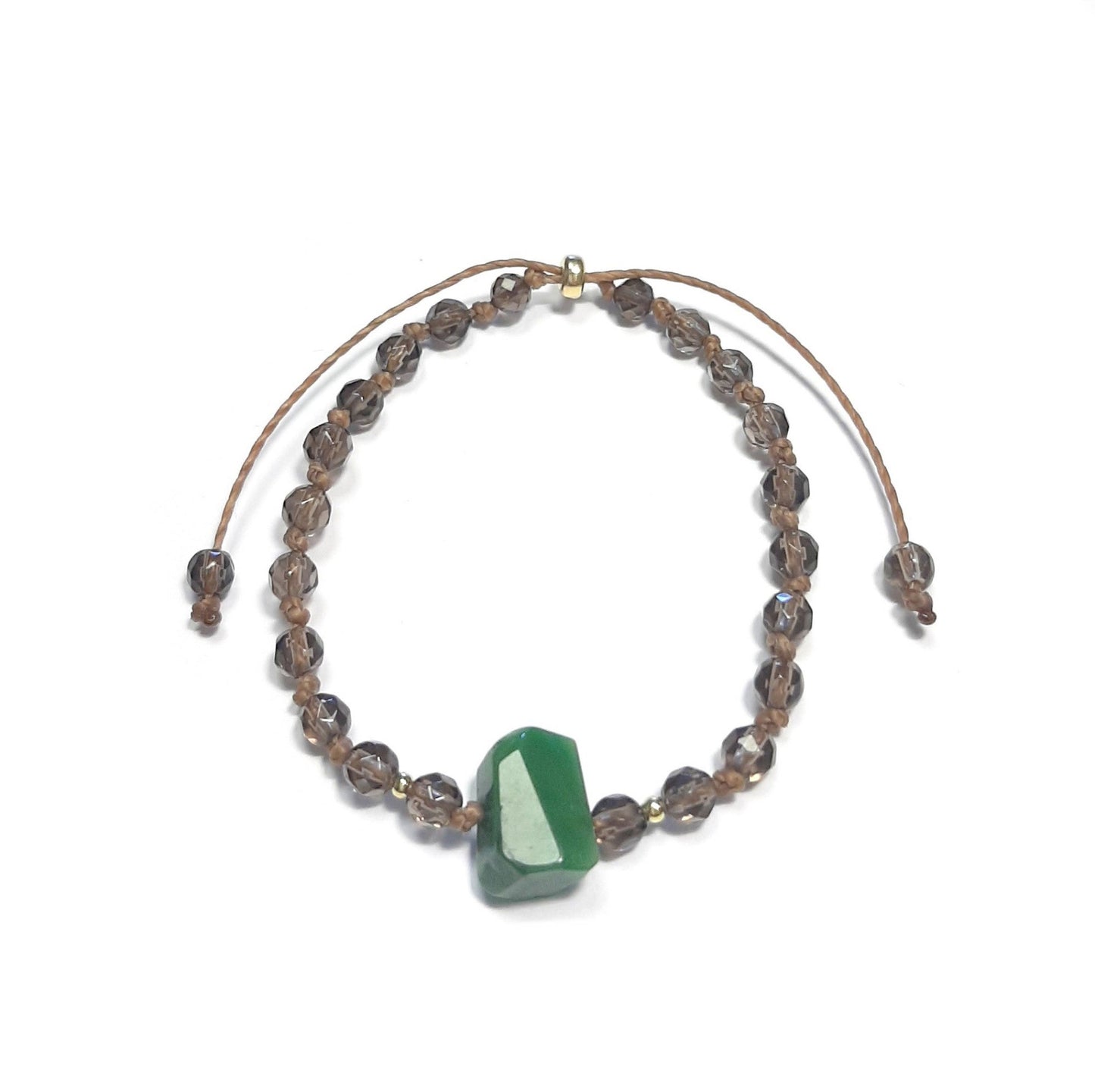 Bracelet en Quartz fumé et Jade – Stabilité & Protection
Ce bracelet artisanal en pierres naturelles marie le quartz fumé, pierre de stabilité et de protection, avec une jade brute centrale, reconnue pour ses vertus apaisantes. Noué à la main, il est orné d’apprêts en argent 925 doré.
Son cordon coulissant le rend facilement ajustable à tous les poignets, offrant un confort optimal.