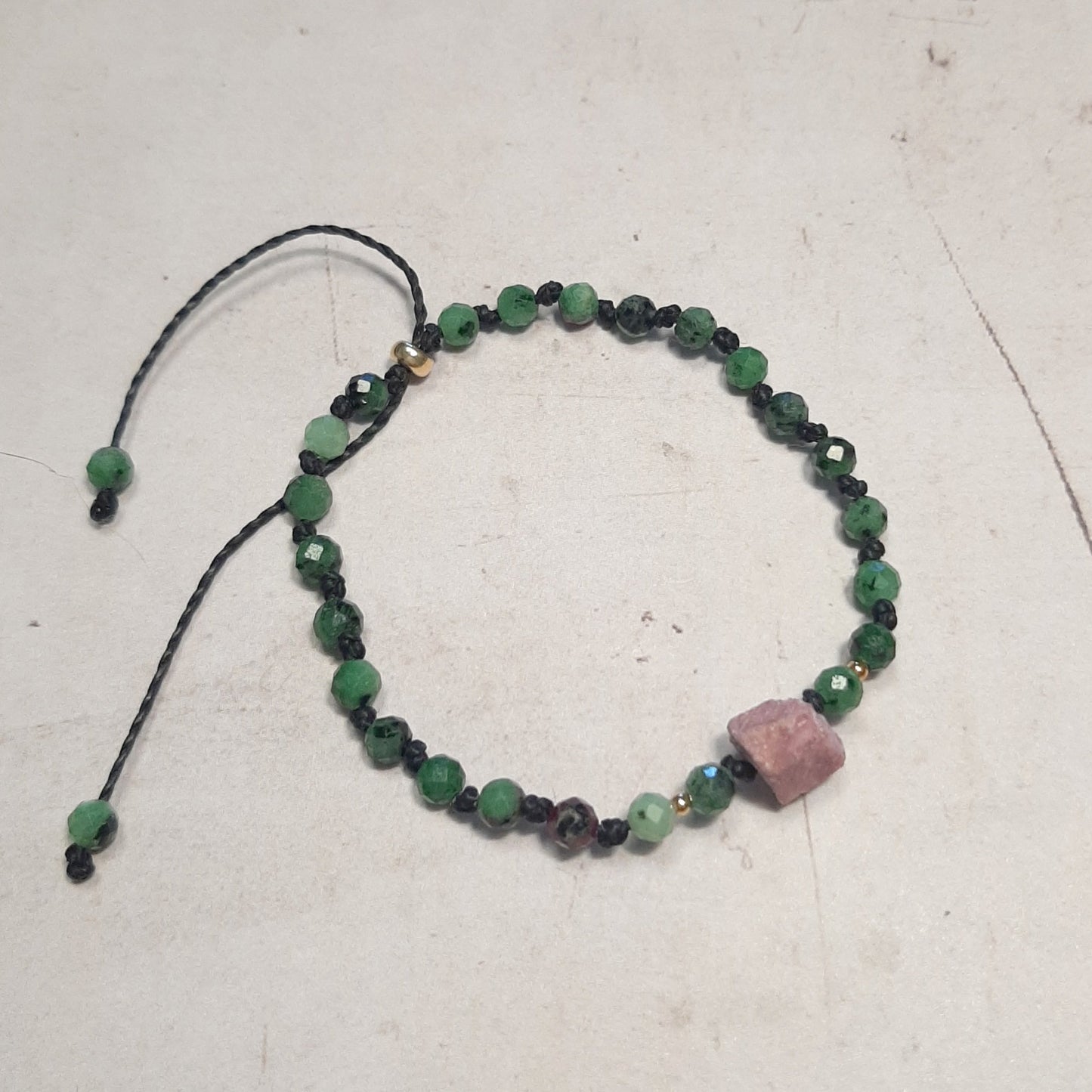 Bracelet ajustable en Zoïsite et Rubis – Force & Équilibre
Alliant l’énergie du rubis brut à la stabilité de la zoïsite, ce bracelet est une véritable invitation à la transformation intérieure. Noué à la main, il est agrémenté d’apprêts en argent 925 doré pour une finition raffinée.
Son cordon coulissant assure un ajustement optimal, dès 15 cm, ce qui le rend parfait pour les femmes et les filles. Chaque bracelet est unique, avec des pierres aux nuances naturelles.