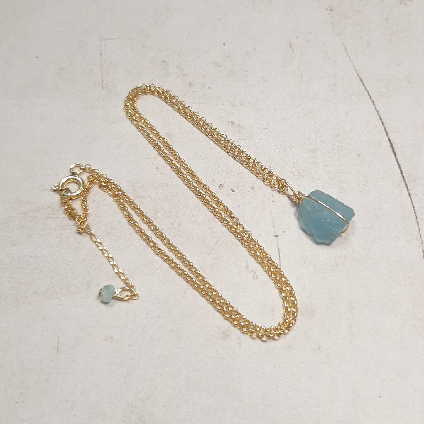 Collier ras du cou fait de aigue-marine brute, montée sur une chaine dorée