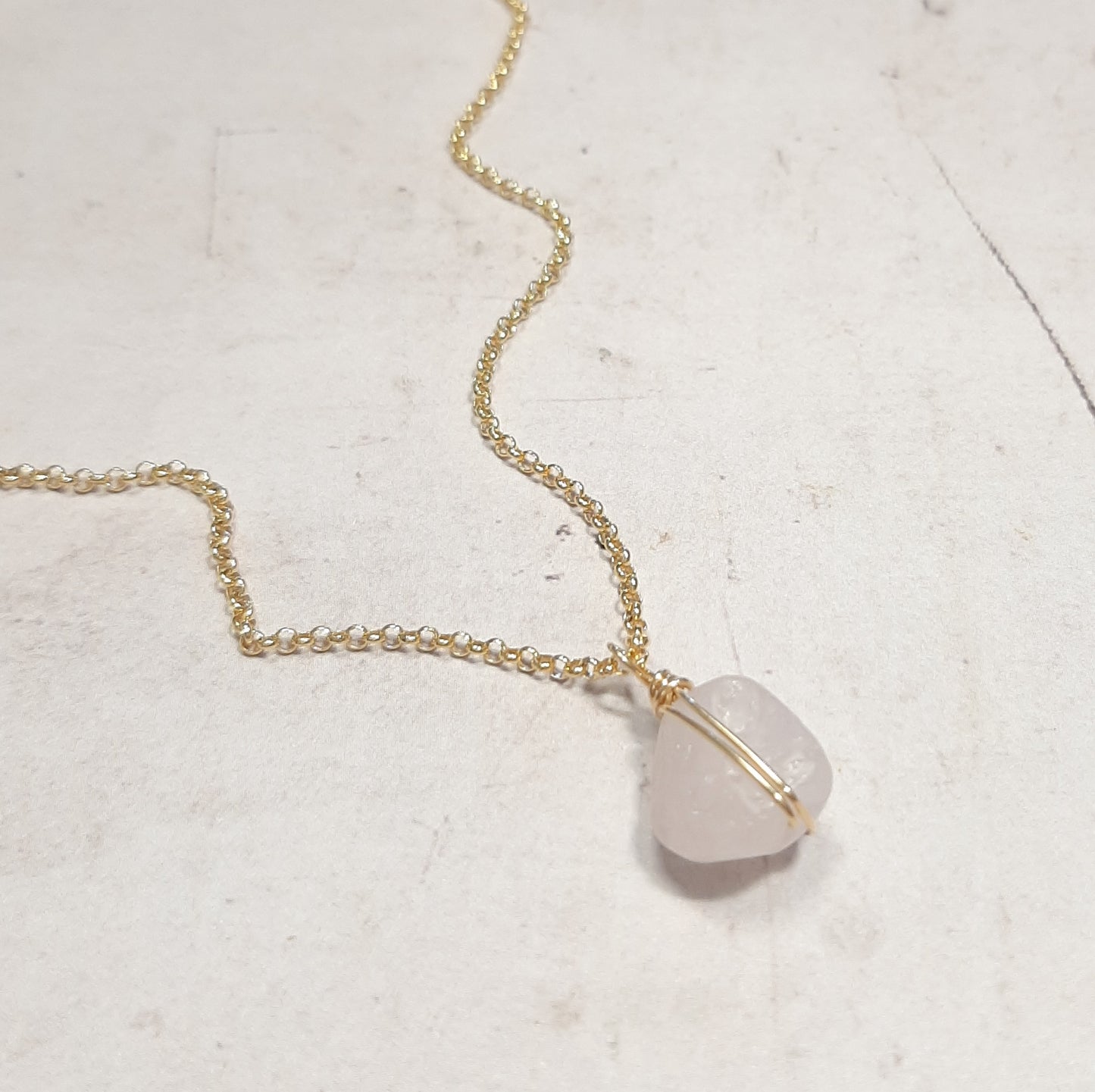 Collier doré mesurant 40cm, orné d’un quartz rose en forme brute.