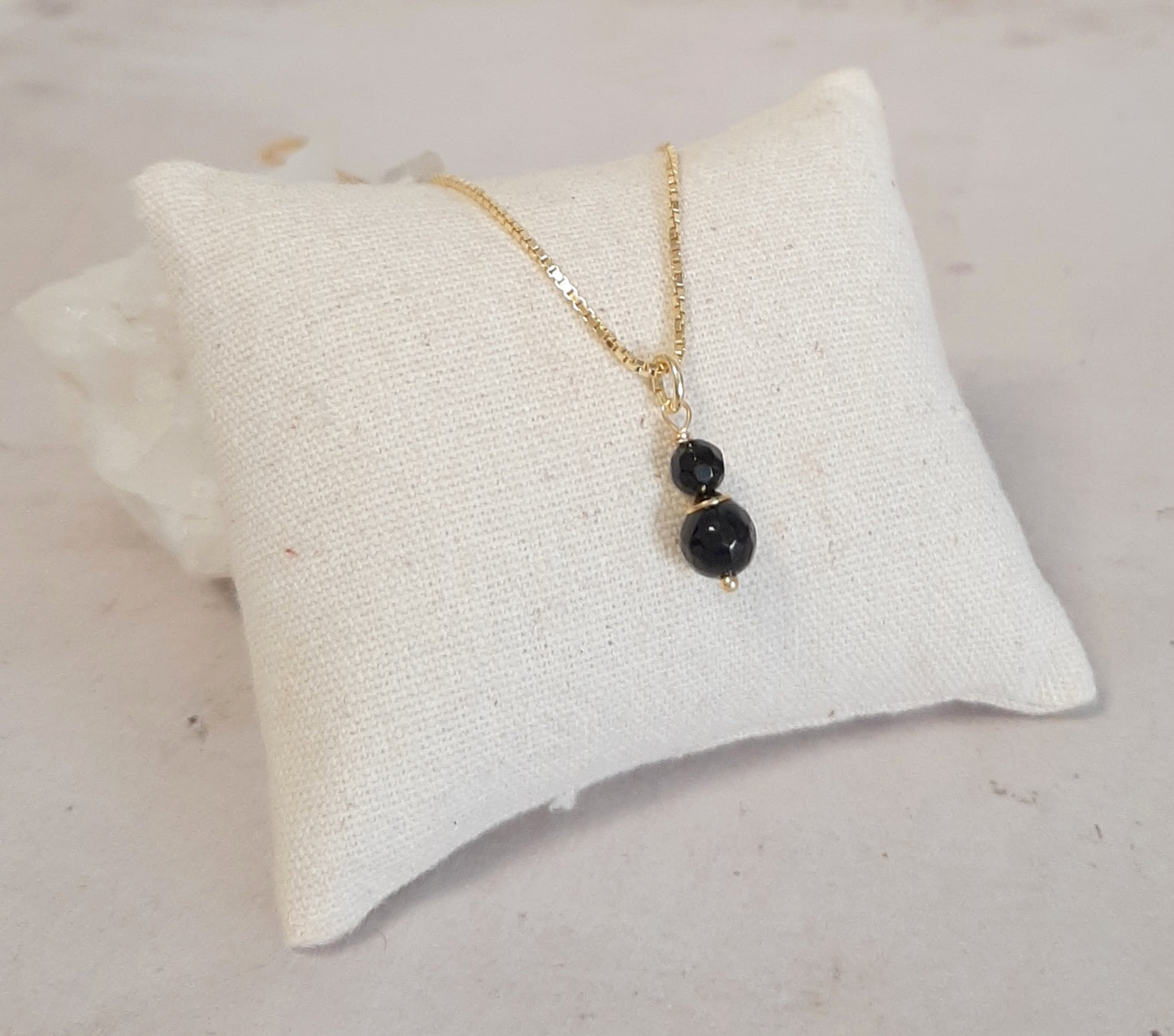 Collier fin en Onyx et argent 925 doré, gros plan sur le pendentif délicat avec la petite pierre d'onyx noir