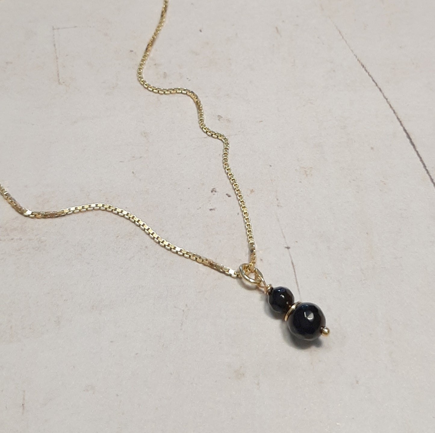Zoom sur la chaîne fine du Collier Talisman Onyx et le fermoir, mettant en évidence la qualité de l'argent 925 doré.