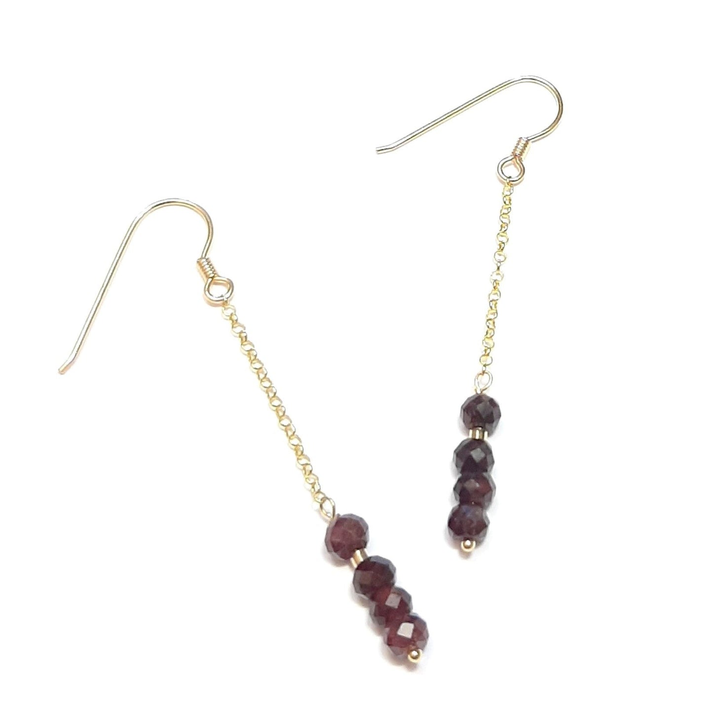 Les boucles d'oreilles en argent 925 doré à l'or fin sont ornées de pierres naturelles de grenat. La longueur approximative de chaque boucle est de 6,3 cm. Chaque pièce, façonnée à la main, peut présenter de légères variations, ajoutant une touche unique à chaque bijou.