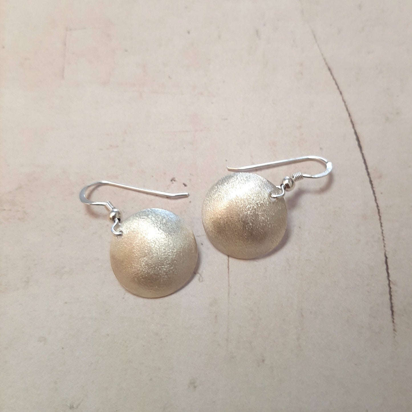 Boucles d'oreilles rondes en argent massif, dotées d'une finition sablée. Légères et discrètes, idéales pour un usage quotidien. La longueur est d'environ 3.3 cm et le diamètre du disque est d'environ 18 mm. Elles apportent une touche de style sans effort à toute tenue.