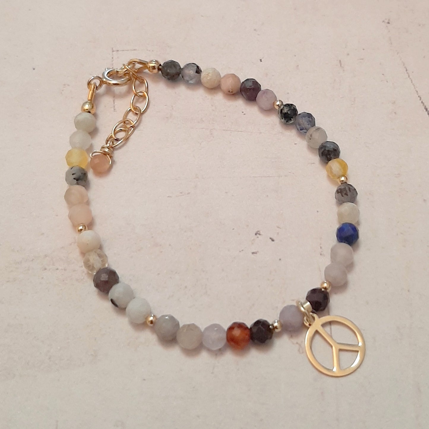 Bracelet doré en pierres naturelles multicolores avec une médaille peace