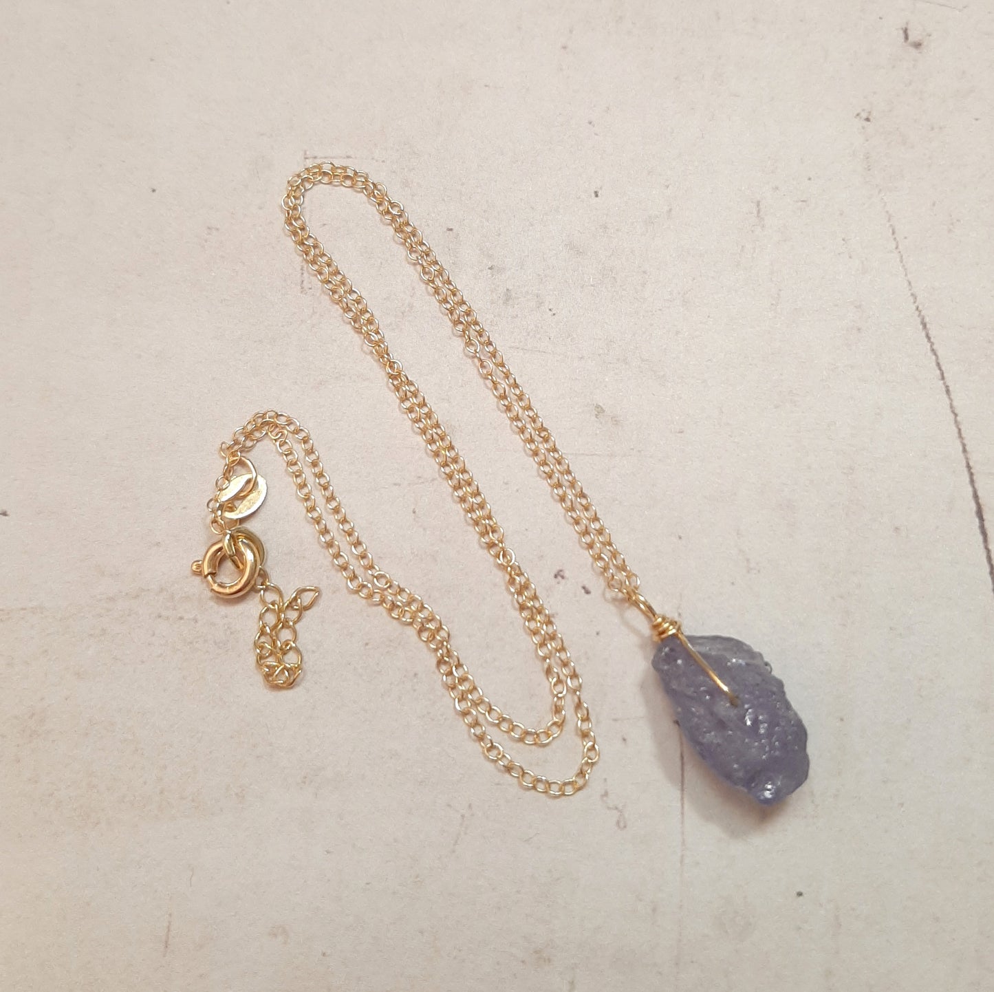 Collier minimaliste en argent doré avec pendentif tanzanite brute, symbole de sérénité et d'intuition.