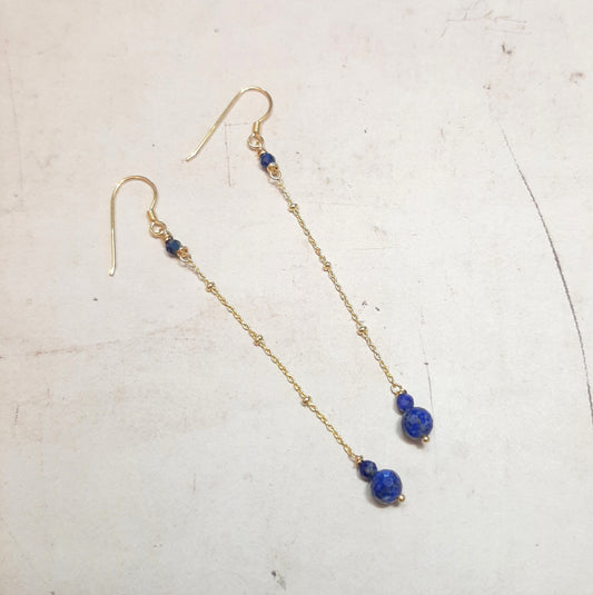 Boucles d'oreilles longues en argent doré, composées d'une chaîne perlée et de pierres naturelles de lapis-lazuli.
