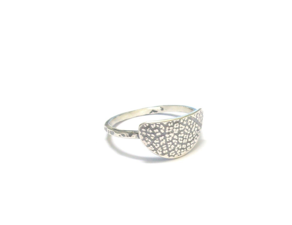 Bague ethnique en argent massif patiné, ornée d'une texture inspirée par une empreinte de feuille de fruit de la passion. Ce design particulier confère à chaque bijou une allure authentique et originale. Façonnée à la main, chaque pièce se distingue par des variations subtiles, créant ainsi un bijou véritablement unique. L’artisanat apporte un charme distinctif, renforçant le caractère singulier de la bague.