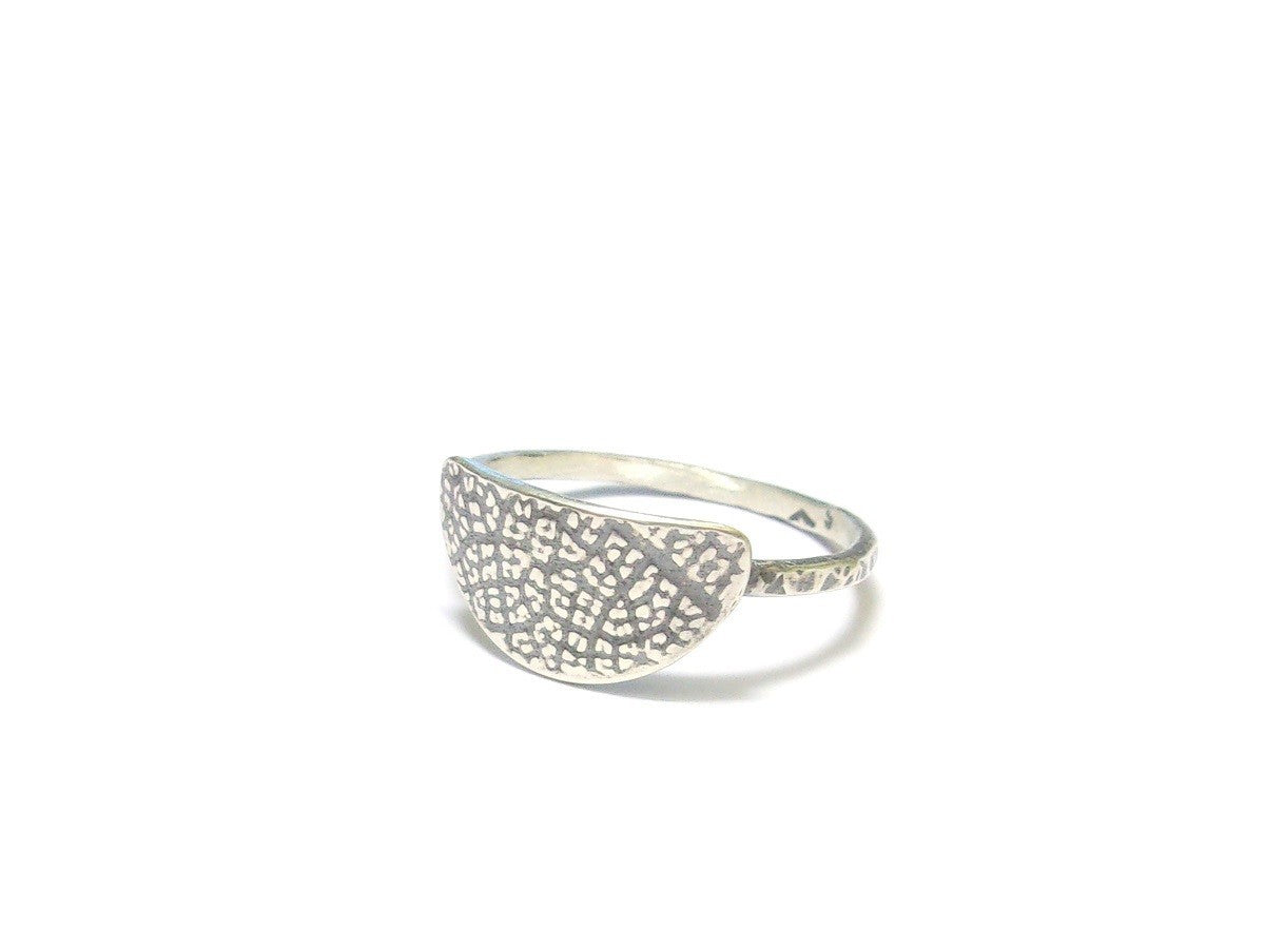 Bague ethnique en argent massif patiné, ornée d'une texture inspirée par une empreinte de feuille de fruit de la passion. Ce design particulier confère à chaque bijou une allure authentique et originale. Façonnée à la main, chaque pièce se distingue par des variations subtiles, créant ainsi un bijou véritablement unique. L’artisanat apporte un charme distinctif, renforçant le caractère singulier de la bague.