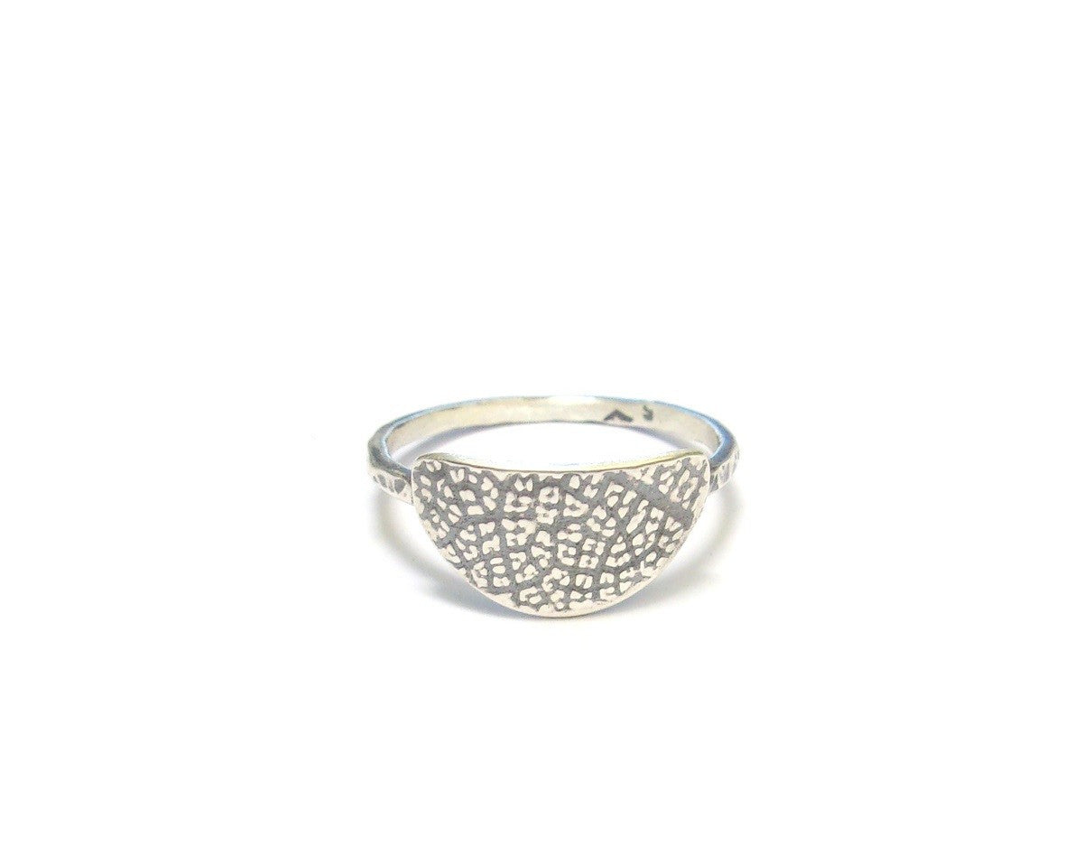 Bague ethnique en argent massif patiné, ornée d'une texture inspirée par une empreinte de feuille de fruit de la passion. Ce design particulier confère à chaque bijou une allure authentique et originale. Façonnée à la main, chaque pièce se distingue par des variations subtiles, créant ainsi un bijou véritablement unique. L’artisanat apporte un charme distinctif, renforçant le caractère singulier de la bague.