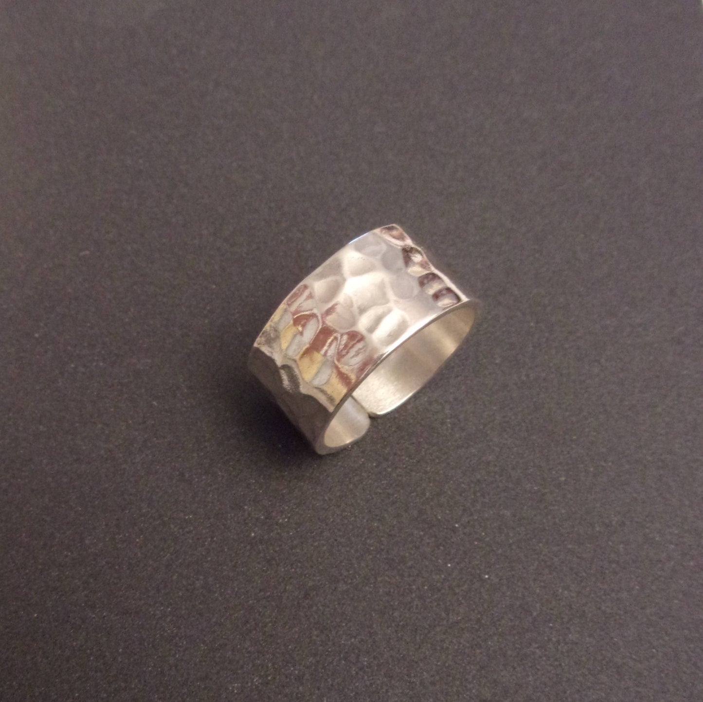 Bague large en argent massif martelé, au design à la fois moderne et intemporel. Avec une largeur de 10 mm, l'anneau se distingue par son allure contemporaine et sa solidité, offrant une pièce durable et résistante à l'usure. Ce bijou élégant s'adapte à tous les styles et ne se démode jamais, en faisant un choix parfait pour toute occasion.
