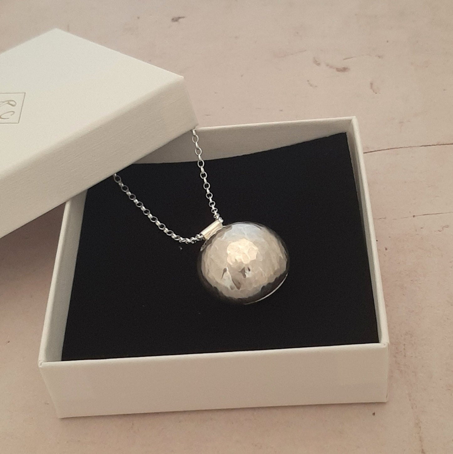 Le sautoir bola en argent massif martelé, orné de pierres fines, est un bijou traditionnel de grossesse inspiré des coutumes indonésiennes. Porté sur le ventre, il émet un tintement doux et harmonieux à chaque mouvement, offrant un effet apaisant pour le bébé. Sa conception en argent véritable et son design délicat en font un accessoire à la fois esthétique et symbolique, idéal pour accompagner la future maman tout au long de la grossesse.