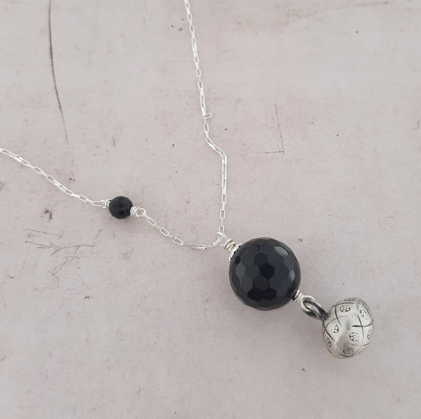 Ce bijou traditionnel de grossesse offre confort et sérénité à la future maman et à son bébé. Composé d'une chaîne en argent et d'un pendentif en onyx, il émet un doux tintement apaisant à chaque mouvement.
bola de grossesse, argent 925, onyx, bijou traditionnel, pendentif, son doux, grossesse,