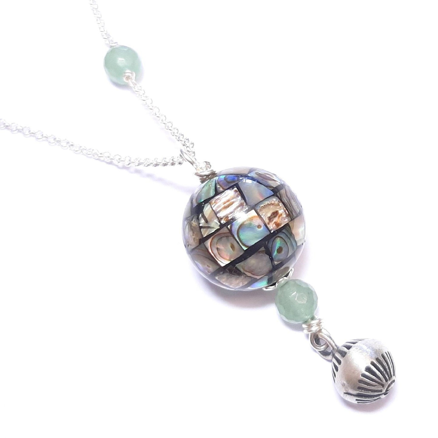 Bola de Grossesse en Argent, Nacre et Aventurine.
Ce bola est composé d'une chaine en argent 925/1000, un pendentif en nacre abalone et aventurine avec une petite cloche argent 925/1000.Les pierres sont naturelles, leurs couleurs et reflets peuvent varier.