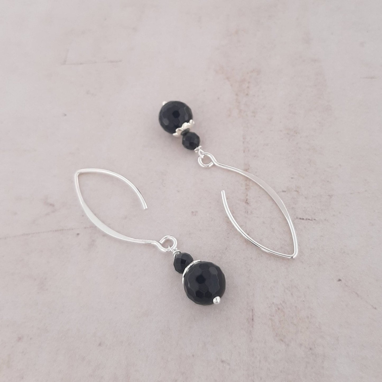 Ces boucles d’oreilles longues en argent 925, ornées de pierres naturelles d’onyx, allient élégance et intemporalité, ajoutant une touche de sophistication à votre style. Mesurant environ 4,5 cm de longueur, elles offrent à la fois beauté et signification. Traditionnellement, l'onyx noir est une pierre de protection contre les énergies négatives, apportant une grande stabilité émotionnelle et stimulant l’énergie physique.