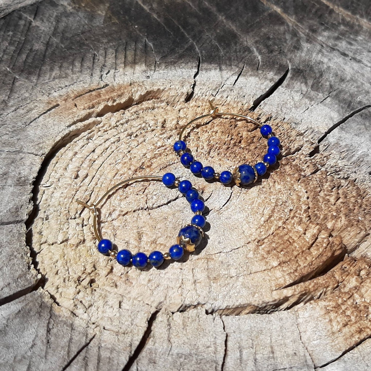 Créoles en Argent 925 Doré et Lapis-Lazuli -
Ces créoles en argent 925 doré, ornées de pierres naturelles de lapis-lazuli, allient charme ethnique et raffinement. Le lapis-lazuli, symbole de sagesse et d’harmonie, apporte une touche de sérénité à chaque tenue. Avec un diamètre de 28 mm, elles sont parfaites pour toutes les occasions. Disponibles également en cornaline et aventurine verte, ces boucles d'oreilles sublimeront vos looks en toute simplicité.