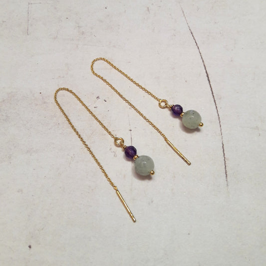 Les boucles d'oreilles chaînes réglables en argent 925 doré à l'or fin 24 carats sont agrémentées de pierres fines, notamment la labradorite et l'améthyste. La longueur totale est d'environ 10,5 cm. La labradorite est connue pour ses propriétés de protection, agissant comme un bouclier absorbant les énergies négatives et préservant l'énergie personnelle.