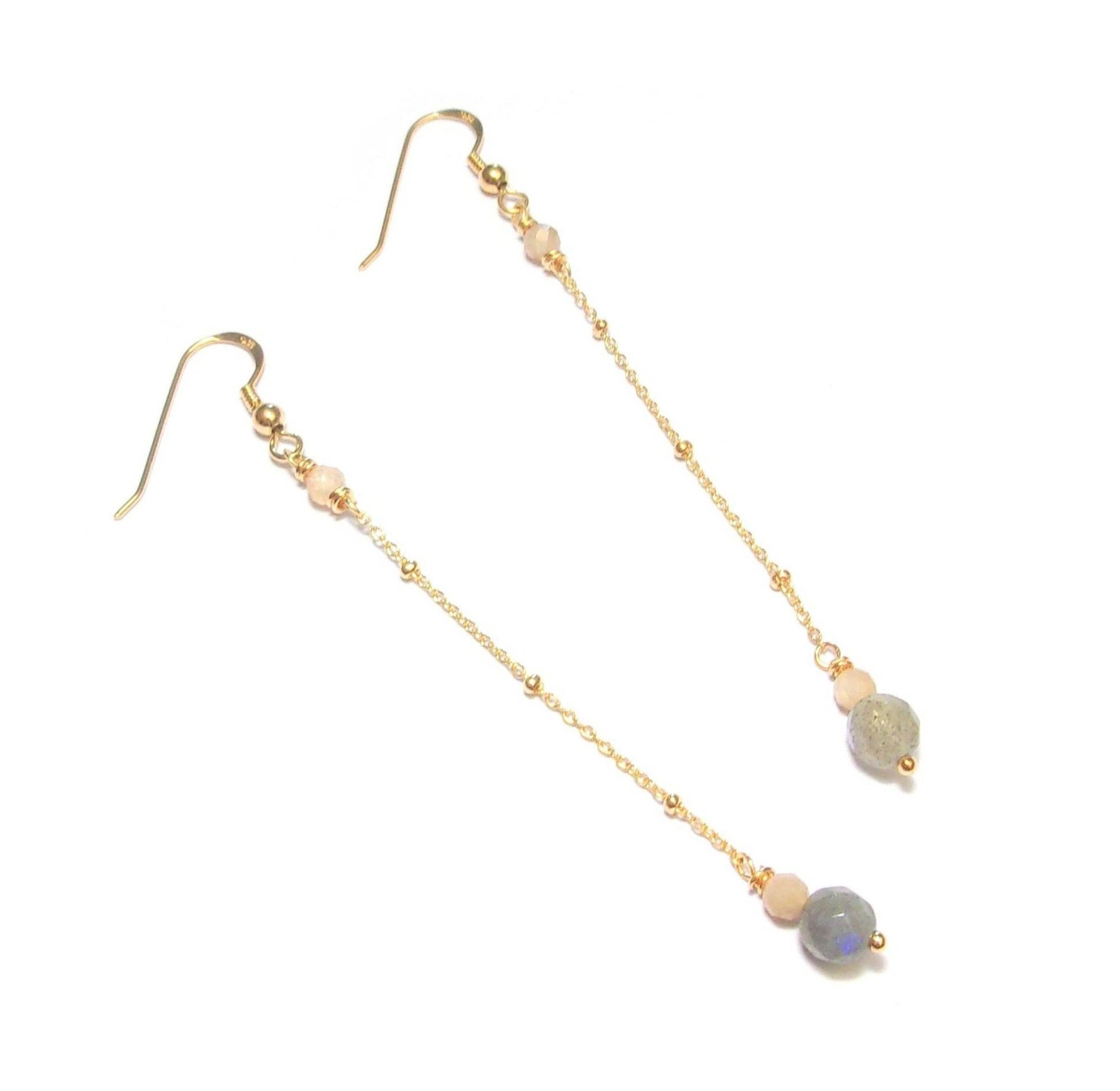 Boucles d'oreilles longues et délicates en argent 925 doré, ornées de labradorite et de pierre de lune, deux pierres fines d'une beauté captivante. Longueur de 8,7 cm environ, avec un diamètre de 6 mm pour la labradorite.