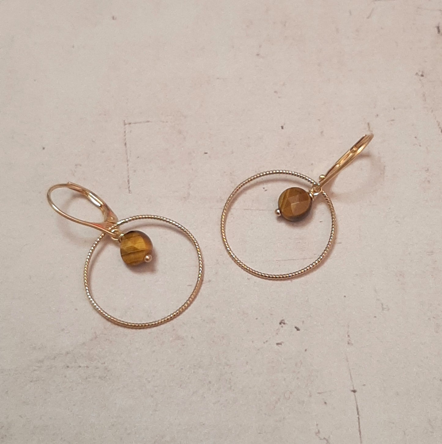 Boucles d'oreilles type dormeuses avec anneaux ciselés ornées de pierres naturelles d’œil de tigre facettée. Longueur : 3.5 cm environ