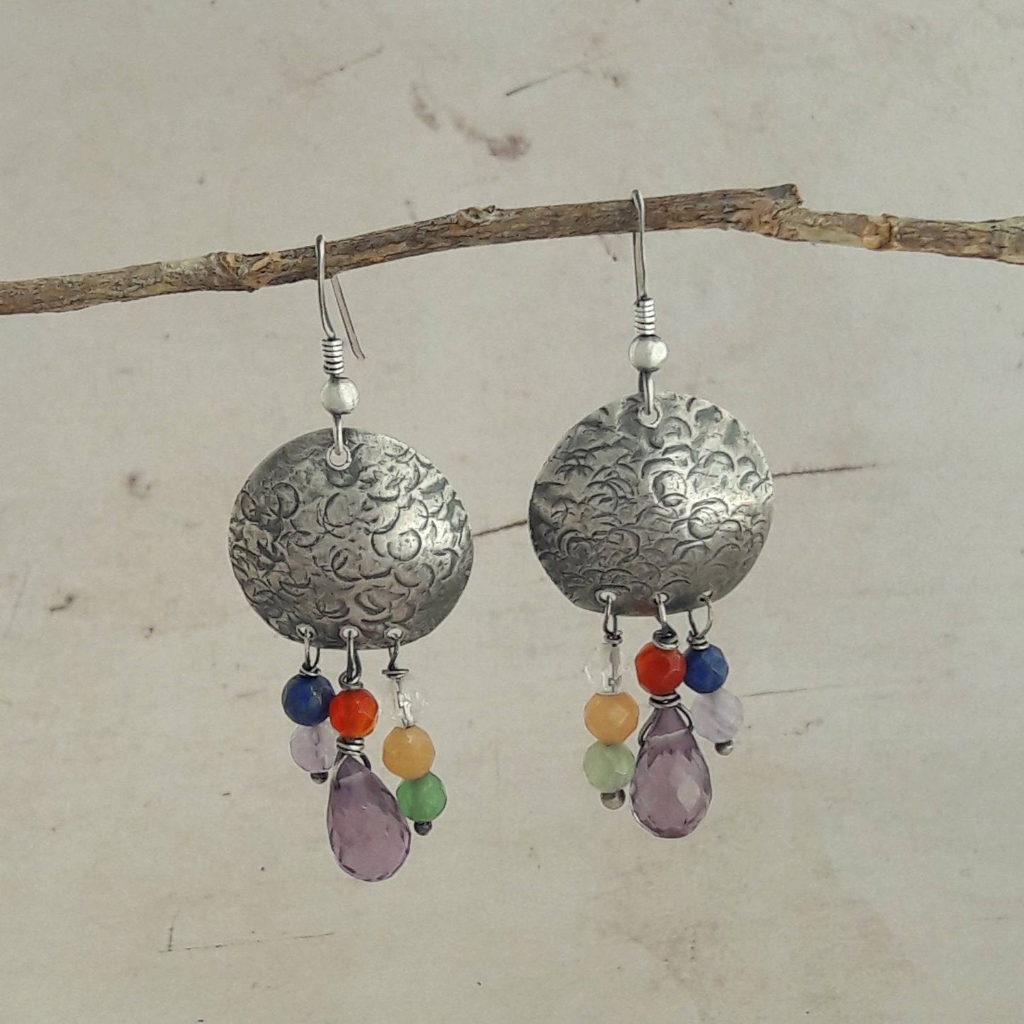 Les boucles d'oreilles ethniques en argent massif patiné et martelé sont ornées de pierres naturelles telles que l'améthyste, le lapis, le cristal de roche, l'aventurine, l'agate et la cornaline.