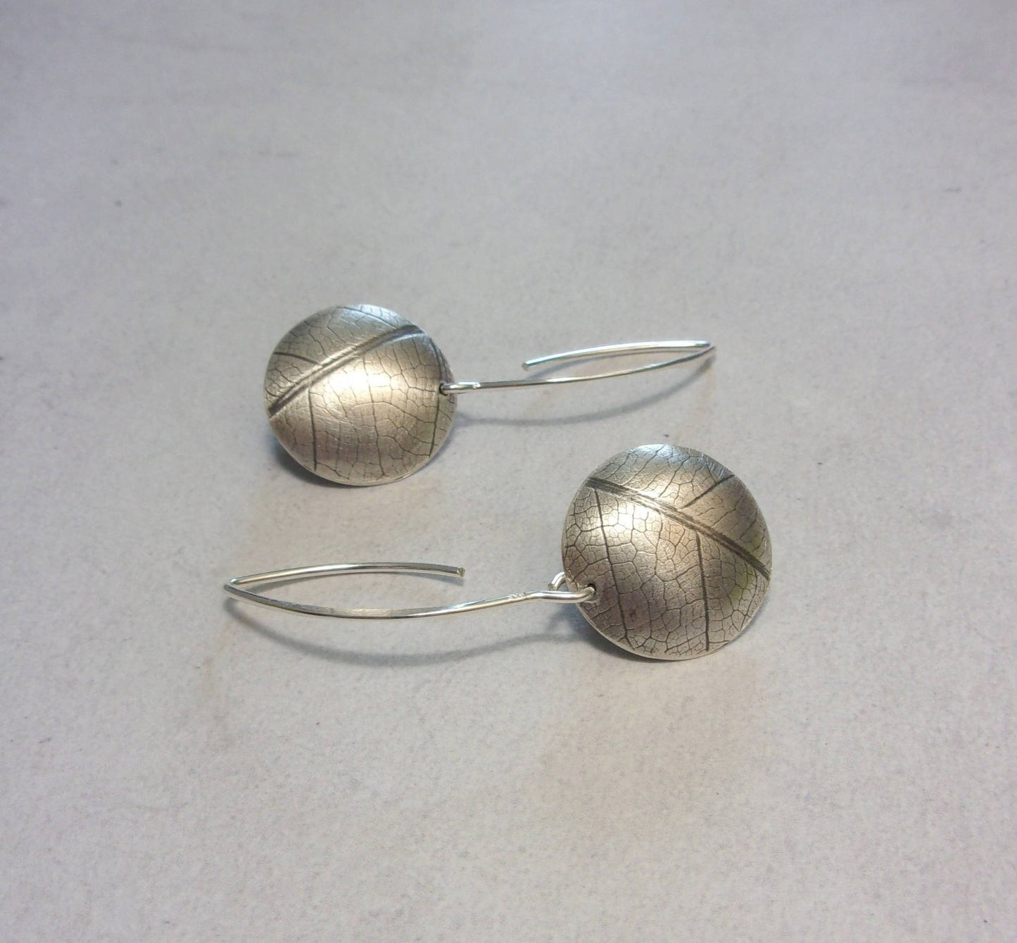 Boucles d'oreilles ethniques en argent massif gravé et patiné, avec une délicate empreinte de feuille de fruit de la passion. Chaque bijou présente une touche d'élégance naturelle et originale. La longueur est d'environ 4.6 cm et le diamètre du disque est d'environ 18 mm.