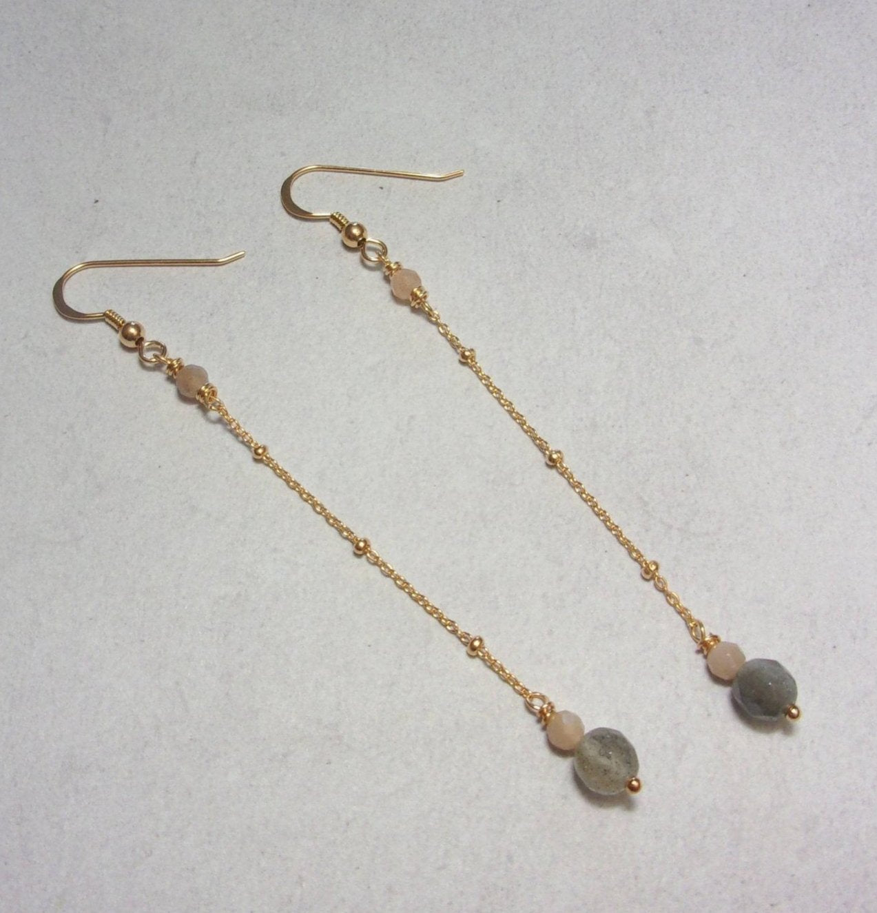 Les boucles d'oreilles longues et délicates en argent 925 doré sont ornées de labradorite et de pierre de lune, offrant une beauté captivante. La longueur est d'environ 8,7 cm avec un diamètre de labradorite de 6 mm.
