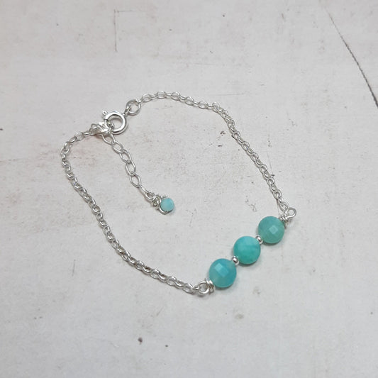 Ce bracelet raffiné mesure 16 cm, avec une chaînette pour un ajustement optimal. Fabriqué en argent 925, il est orné de pierres naturelles d'amazonite, dont les teintes peuvent varier légèrement, ajoutant une touche d'unicité à chaque pièce. L'amazonite est connue pour ses propriétés apaisantes, favorisant la joie de vivre et l'importance de l'instant présent. Ce bracelet constitue un choix idéal pour marquer des moments spéciaux ou pour apporter une note d'élégance au quotidien.