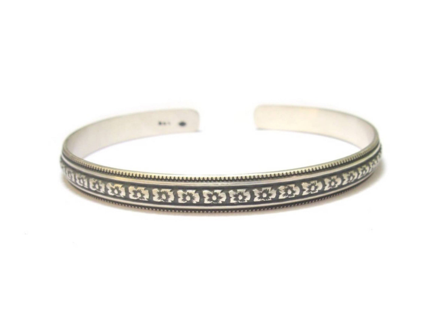 Le bracelet Angra en argent massif 925 allie artisanat traditionnel et élégance contemporaine. Gravé à la main et patiné, ce jonc ethnique s'adapte à toutes les morphologies grâce à sa taille réglable. Bijoux durables et responsables