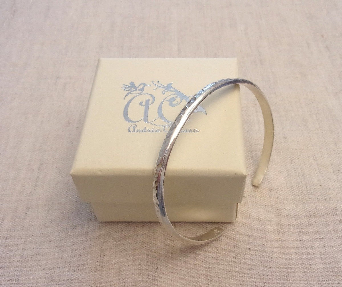 Bracelet jonc ouvert en argent massif martelé, avec un design épuré. Taille unique et réglable, s'adaptant facilement au poignet pour un confort optimal. Un bijou intemporel et élégant. Diamètre intérieur de 60 mm, épaisseur de 4x2 mm.