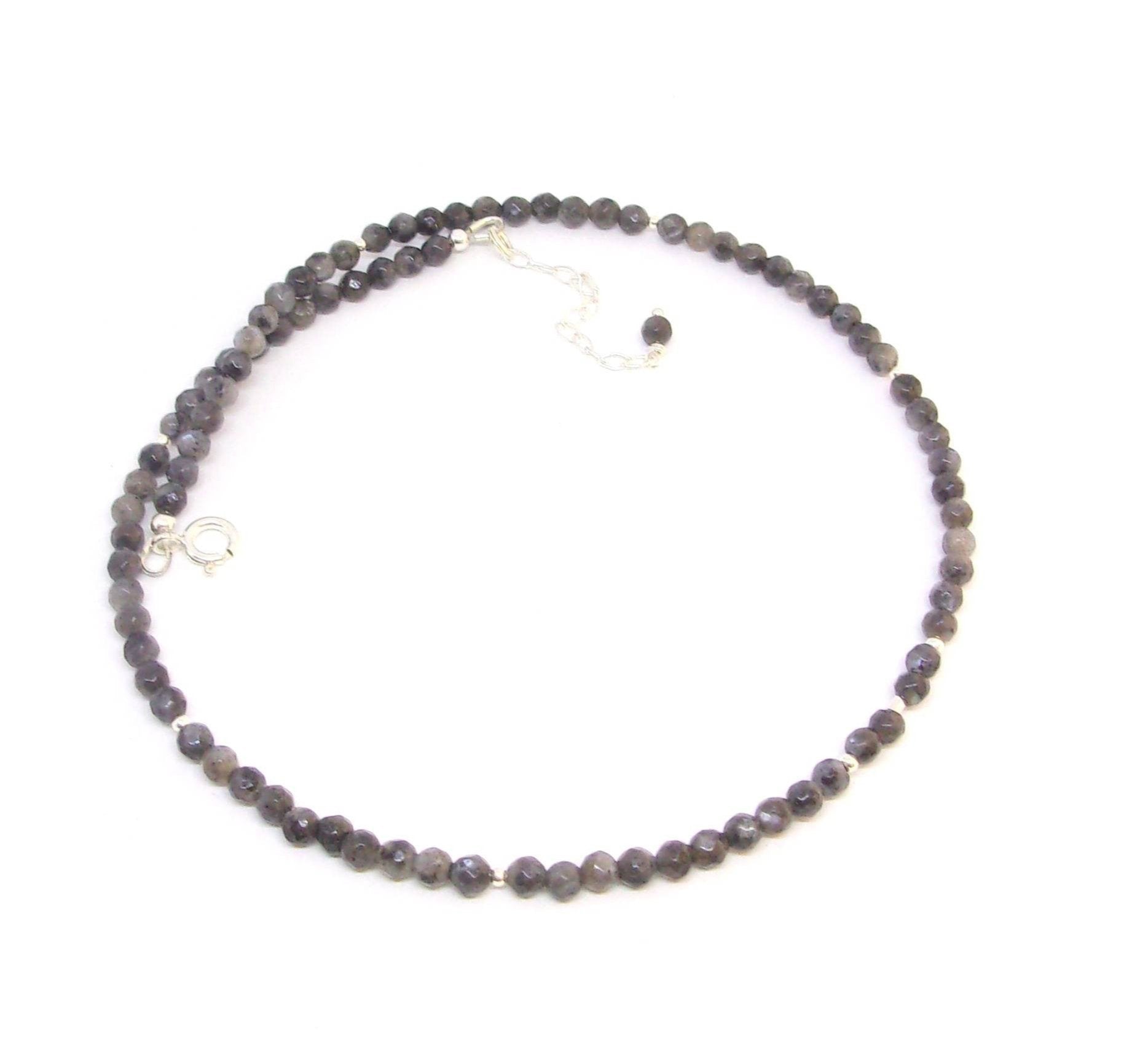 Collier  en argent 925, orné de pierres fines de labradorite noire, aussi appelée larvikite. Le collier mesure 40 cm de long, avec une chaîne supplémentaire pour ajustement. Les pierres de labradorite, de 4 mm de diamètre, apportent une touche élégante et mystérieuse.