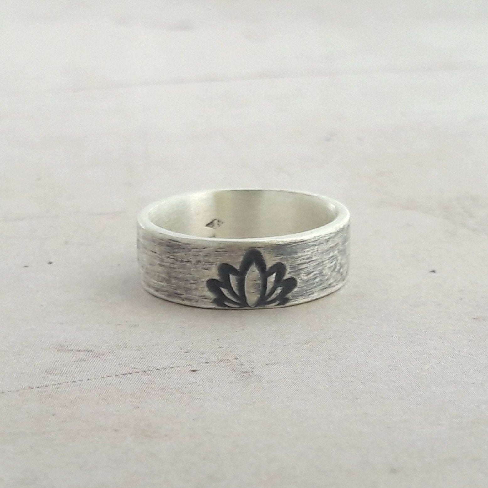 Découvrez notre bague ethnique en argent massif, ornée d'une gravure de fleur de lotus, symbole de pureté et de renouveau. Bijou artisanal unisexe, parfait pour un style spirituel et élégant.