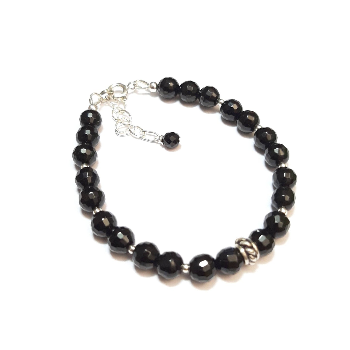 Ce bracelet élégant associe la puissance protectrice de l'onyx noir avec la brillance intemporelle de l'argent 925. L'onyx, pierre de force et de résilience, est soigneusement sélectionné pour un bijou qui incarne l'élégance et la protection. Chaque bracelet est fabriqué à la main en France, mesurant 17 cm avec une chaînette ajustable pour un confort parfait.