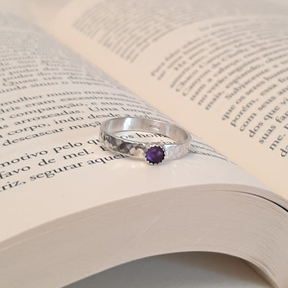 Bague en argent 925 au design intemporel, martelé pour une texture unique, ornée d'une pierre naturelle d'améthyste de 4 mm de diamètre. Avec une largeur de 3,2 mm, elle incarne à la fois simplicité et élégance. L’améthyste, connue pour ses propriétés apaisantes, est souvent associée à la sérénité, l'équilibre et la tempérance, favorisant la méditation et renforçant l’intuition.