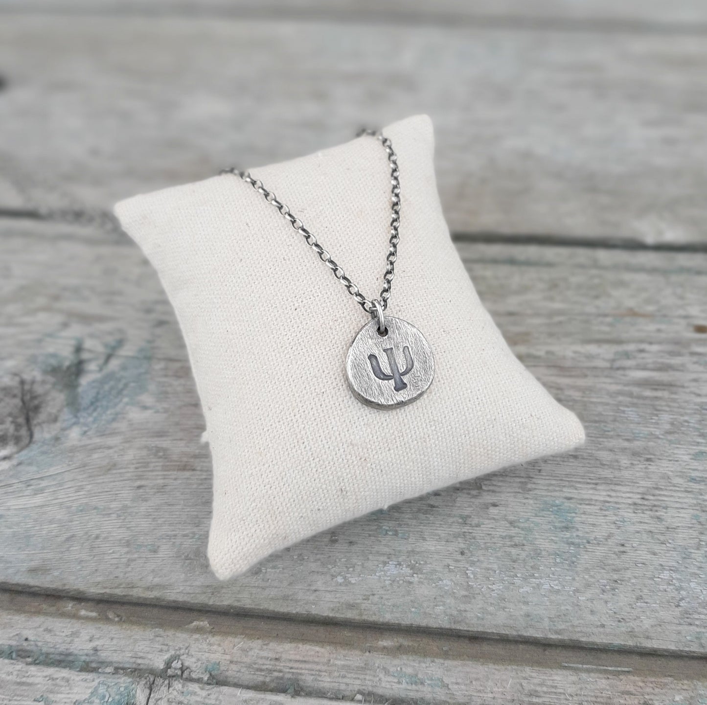 Bijou Porteur de Sens.
Ce collier en argent 925 patiné, avec son pendentif gravé du symbole Psi Ψ, est bien plus qu’un simple bijou. Il incarne la réflexion, la connaissance et la quête intérieure. 
Un bijou chargé de sens et d’authenticité, parfait pour ceux qui aiment les accessoires symboliques.