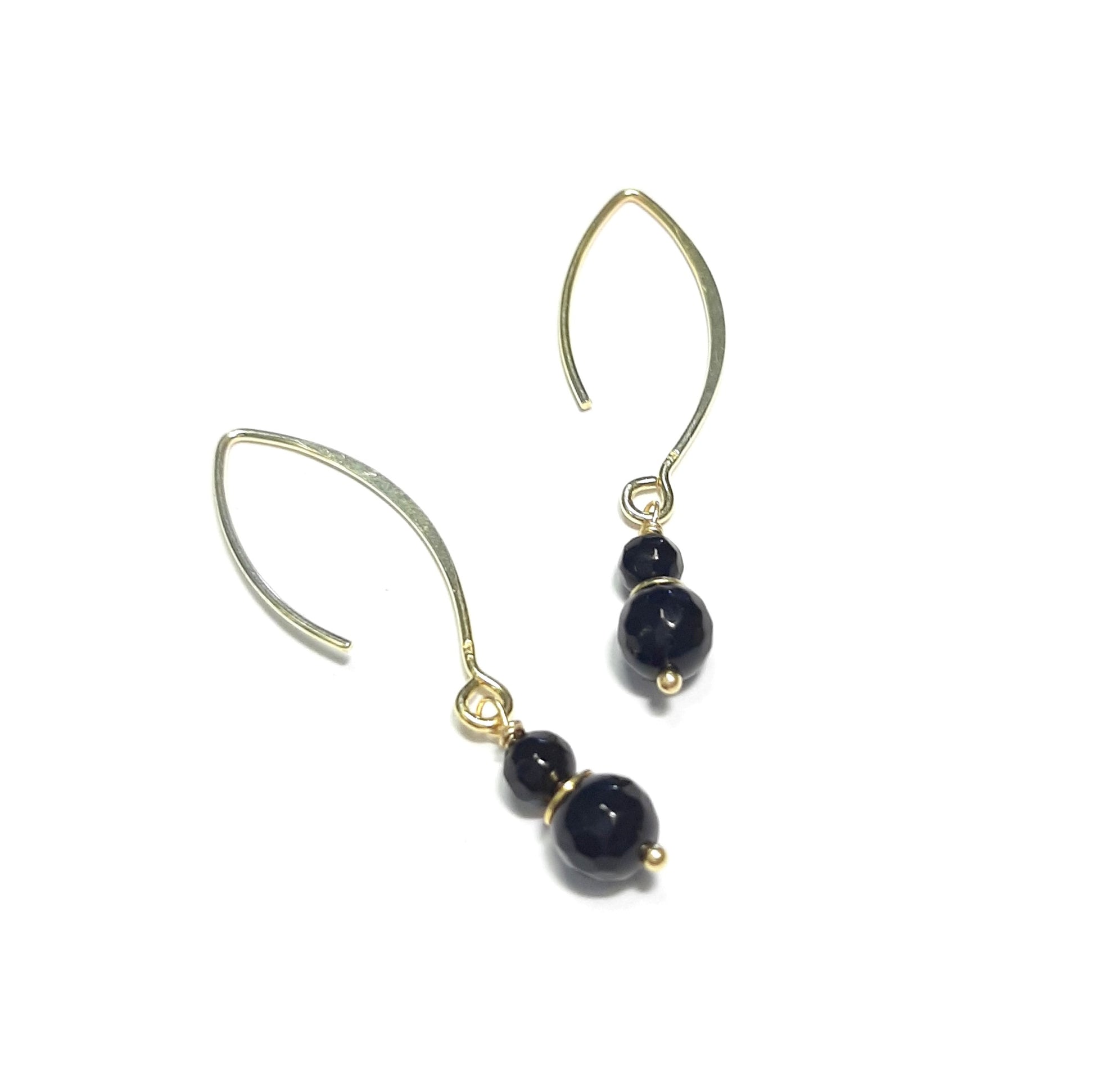 Boucles pendantes en argent massif doré rehaussées de perles d’onyx noir. Design épuré, finition brillante, portée légère (4,5 cm). Fabriquées en France dans le respect des matières naturelles — bijoux responsables et intemporel.