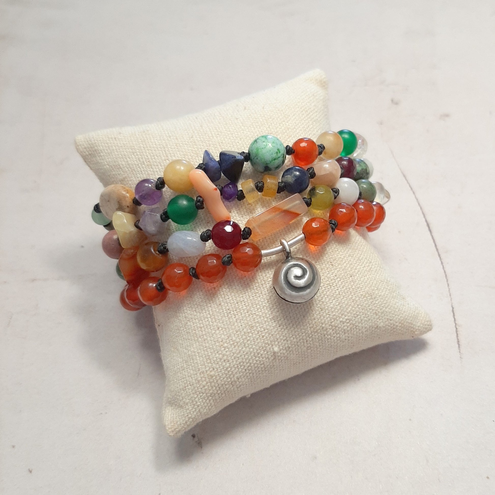 Bracelet ethnique appeleur d'anges en pierres naturelles et argent 925 présenté sur coussin de bijouterie
