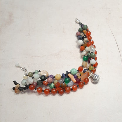 Bracelet appeleur d'anges déroulé sur fond blanc – détail des pierres naturelles multicolores et grelot en argent 925