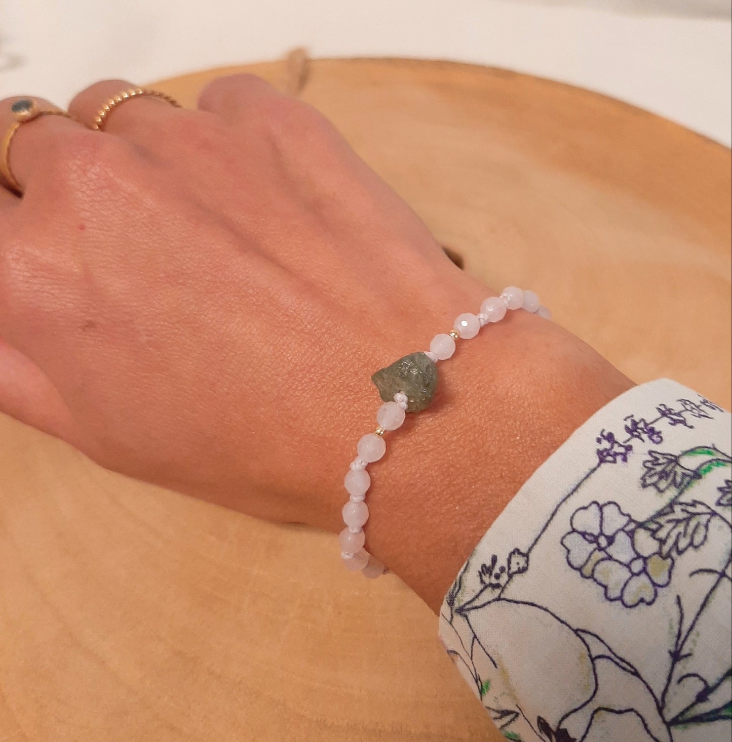 Bracelet brésilien en pierres naturelles de quartz rose, orné d'ungrenat vert  brut en son centre. Un bracelet porte-bonheur, ajustable grâce à sa fermeture coulissante.