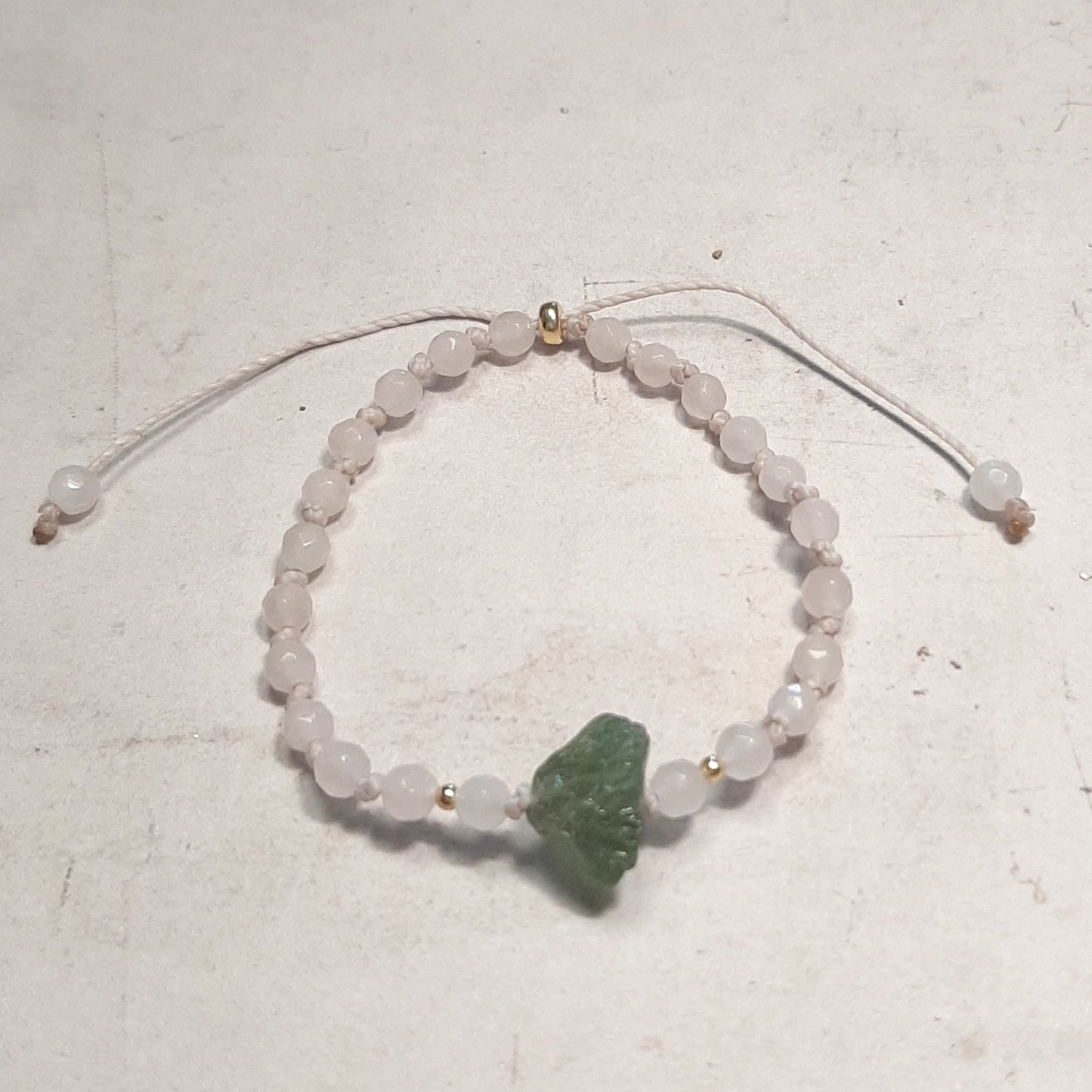 Bracelet ajustable en Quartz rose et Grenat vert – Douceur & Énergie
Laissez-vous séduire par ce bracelet en pierres naturelles, mêlant la douceur du quartz rose, pierre d’amour et de sérénité, à la force du grenat vert, symbole de vitalité et de renouveau. Noué à la main, il allie élégance et bien-être énergétique.

Son cordon coulissant s’adapte facilement à tous les poignets, dès 15 cm, ce qui le rend idéal aussi bien pour les femmes que pour les filles. 
