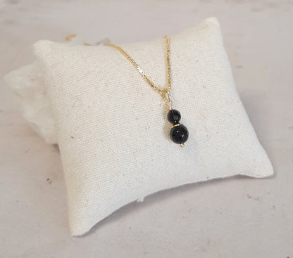 Collier fin en Onyx et argent 925 doré, gros plan sur le pendentif délicat avec la petite pierre d'onyx noir