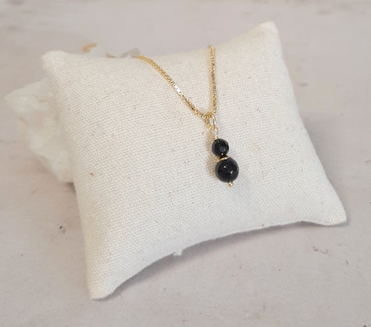 Collier fin en Onyx et argent 925 doré, gros plan sur le pendentif délicat avec la petite pierre d'onyx noir