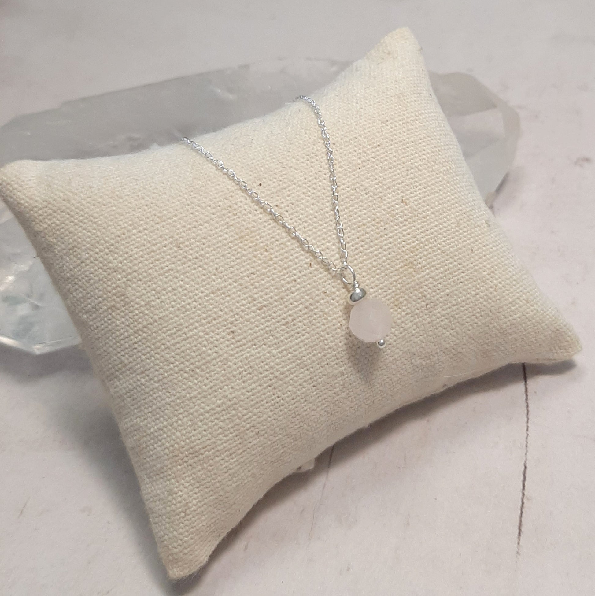 Flat lay collier quartz rose argent 925 sur fond neutre