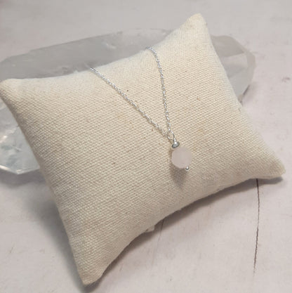 Flat lay collier quartz rose argent 925 sur fond neutre