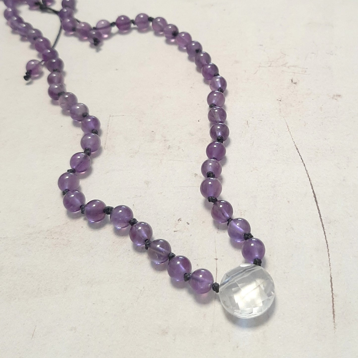 Gros plan du pendentif en cristal de roche facetté du mala améthyste – Andréa Chereau