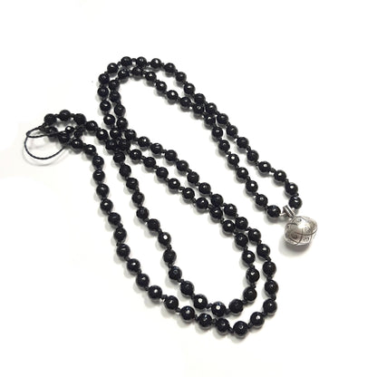 Détail des perles en onyx noir et pendentif spirituel en argent massif